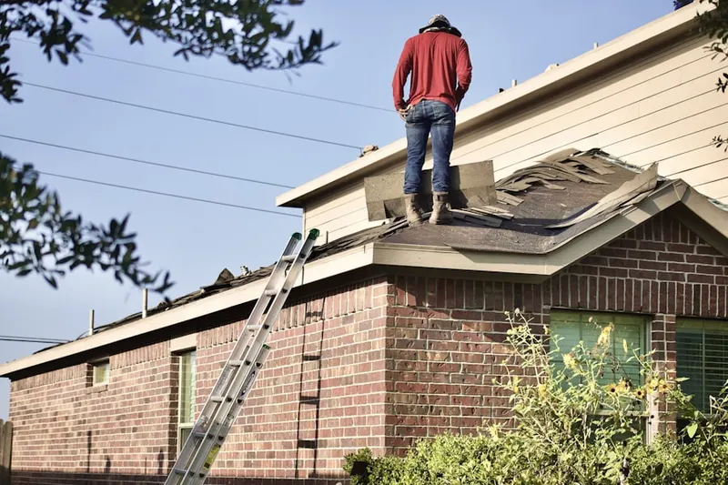 Professional roofer working on a residential roof in Little Italy
